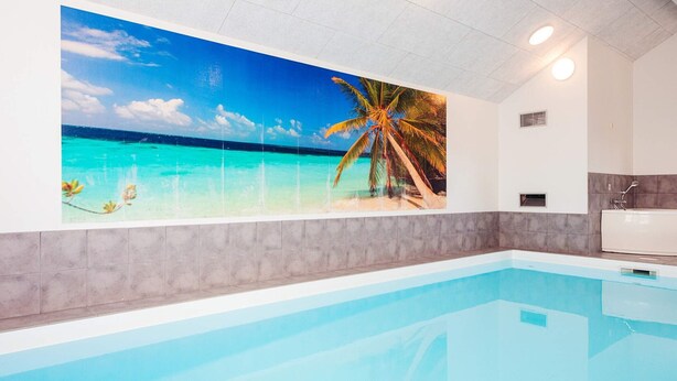 A swimming pool with a tropical mural, a shower area, and a tiled ceiling. - 5 Star Holiday Home in Hadsund (Hadsund)