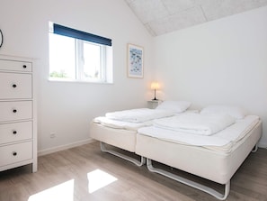 Ein Schlafzimmer mit Bett, Schminktisch, Fenster mit Blick und Lampe.