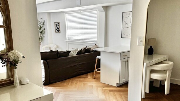 Un apartamento moderno con comedor, sala de estar con sofá y cocina.