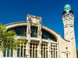 A historic building with a clock tower, large arched windows, and ornate stone carvings. - XAVIER – F2 cosy avec balcon et parking à Rouen (Rouen)