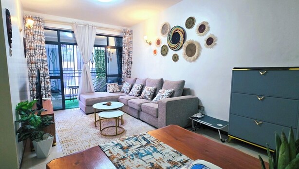 Una sala de estar con sofá, mesa de centro y un aparador.