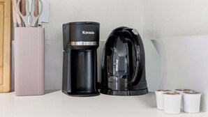 Una cafetera y un hervidor en la encimera de la cocina.