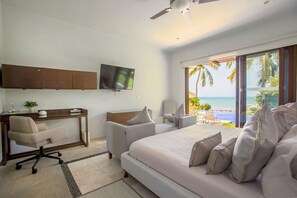 A bedroom with a bed, a desk, a chair, a television, and a view of the ocean. - Beachfront Villa with Pool & Ocean Views (Cruz de Huanacaxtle)