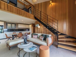Ein geräumiger Wohnbereich mit einer Couch, einem Couchtisch und einer Treppe.