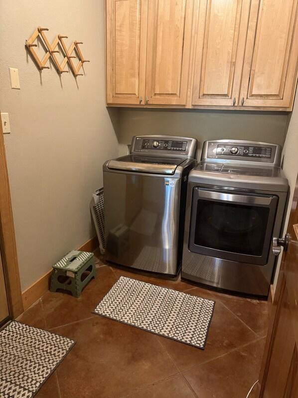 A compact kitchen with stainless steel appliances, wooden cabinets, and a patterned rug on the floor. - The Great Troutdoors, Heber Springs, AR (Heber Springs)