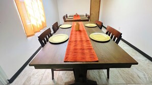 A conference room with a long table, chairs, and a door.