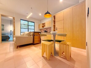 Ein modernes Interieur mit einer Couch, einem Esstisch, Stühlen und Holzausbau.