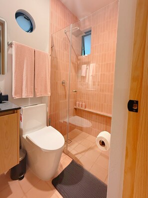 Ein Badezimmer mit Toilette, Dusche und Waschbecken.
