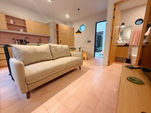 A modern kitchen with a beige sofa, wooden cabinets, and a small dining table. - Serene 2-bedroom apartment in charming Guadalajara perfect for relaxing stay (Guadalajara)
