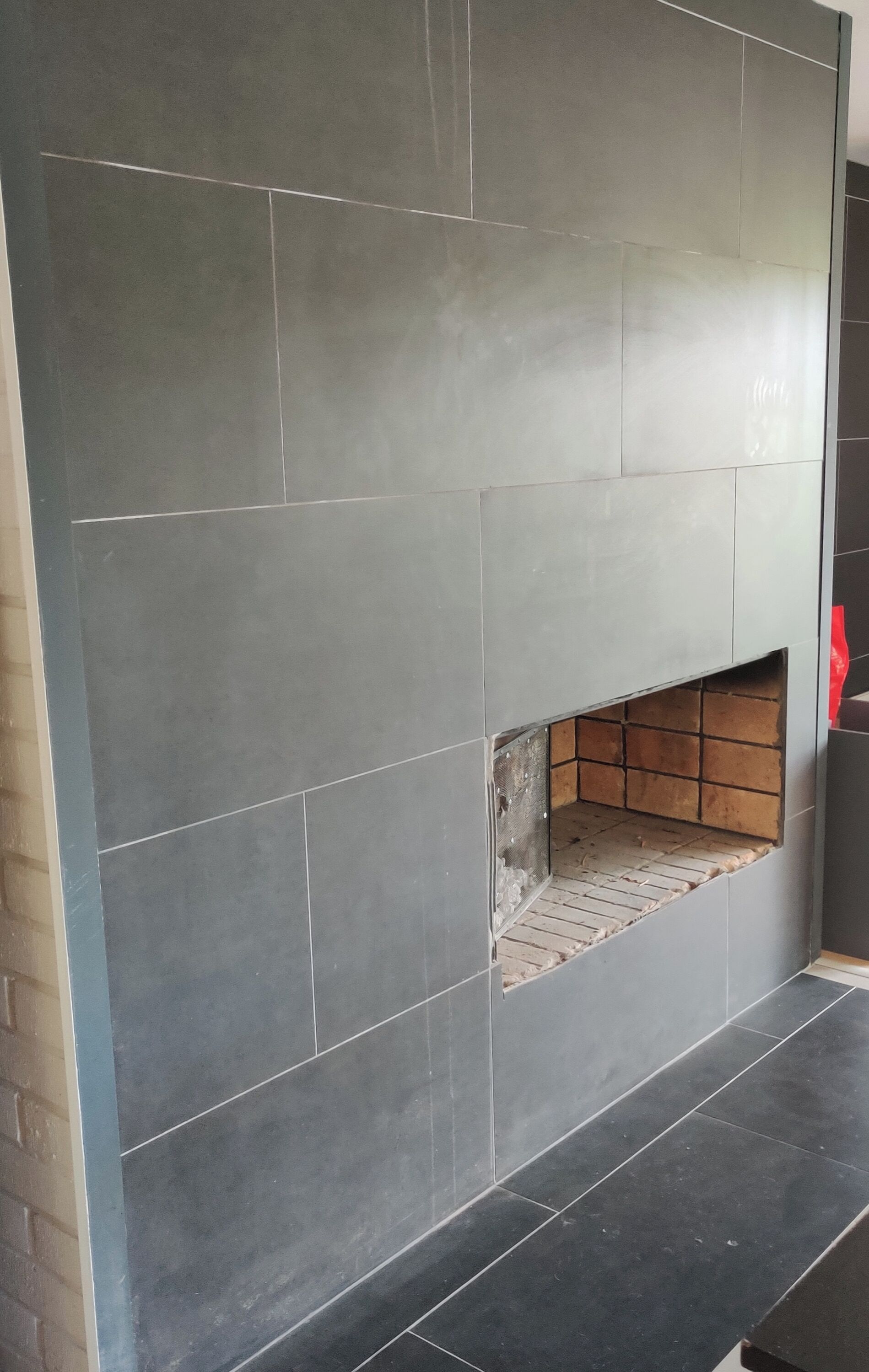 Pared con azulejos y un espacio hundido para chimenea.
