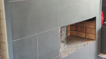 Pared con azulejos y un espacio hundido para chimenea.