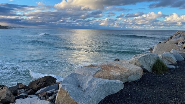 A coastal landscape with large rocks and the ocean.