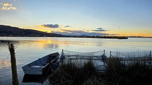 Ein ruhiger See mit einem Boot, das an der Ufer angelegt ist, umgeben von Schilf.
