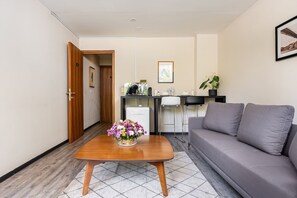 A modern room with a wooden coffee table, a grey sofa, a kitchenette, and a door leading to another room. - Hermoso Departamento- Corazón Polanco (Tabaco) (Ciudad de México)