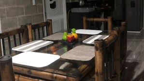 A dining area with a glass table, wooden chairs, and a kitchen in the background. - 3-bedroom house in amazing Darién with cool AC breeze (Darién)