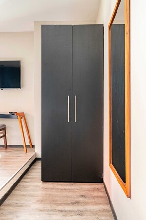 A room with a black wardrobe, a wooden chair, a desk, and a large mirror. - Loft Con Terraza Privada en Corazon Polanco (Ciudad de México)