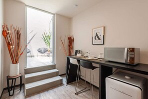 A modern kitchen with a microwave, bar stools, and a coffee machine. - Super Loft Corazon Polanco (Abedul) (Ciudad de México)