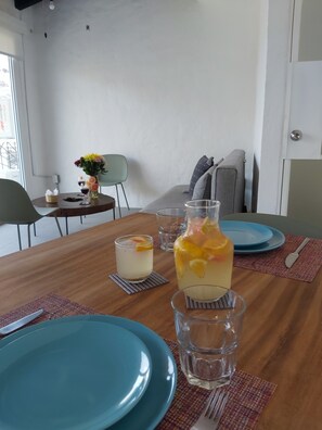 A dining table with blue plates, a pitcher of fruit drink, and a glass of water. - Beautiful apartment with a view of the small town and just 10 minutes from the Romantic District. (Puerto Vallarta)