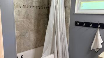 Een douche, handdoeken, zeep, toiletpapier