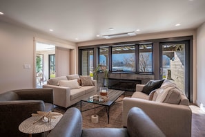 A modern living room with a sofa set, a glass coffee table, and a fireplace. - Luxury Lakefront Condo C1 + BBQ in Wapato Chelan (Manson)