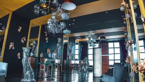 A modern interior with a bar area, reflective decor, and a chandelier.