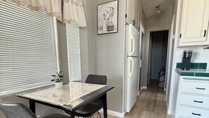 Une cuisine moderne avec une table à manger, des chaises et un réfrigérateur.