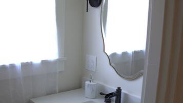 Een douche, handdoeken, zeep, toiletpapier