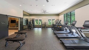 Ett gym med löpband, styrketräningsmaskiner och en vägg full av speglar.