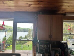Una cocina con armarios de madera, una cafetera Bosch y vistas a un lago.