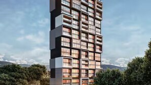Een hoog gebouw met meerdere balkons, omgeven door groen en een heldere lucht.