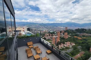 Eine Dachterrasse mit Sitzgelegenheiten und Blick auf die Stadt.