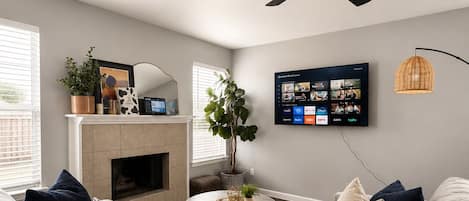 Een smart-tv, een open haard, boeken en een computerscherm