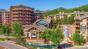 Un hotel con varios pisos, piscina y una cascada.
