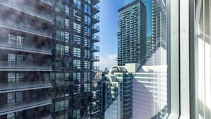 En moderne højhusbygning med flere altaner og en glasfacade.