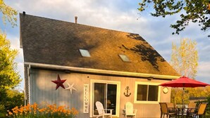 Una casa con un letrero que dice 'WELCOME', una decoración con forma de estrella y una terraza con sillas y una mesa.