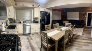 Una cocina moderna con comedor, horno empotrado y refrigerador.