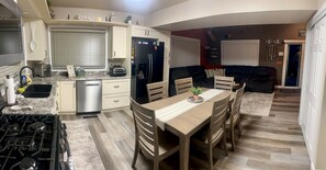 A modern kitchen with a dining area, a built-in oven, and a refrigerator.
