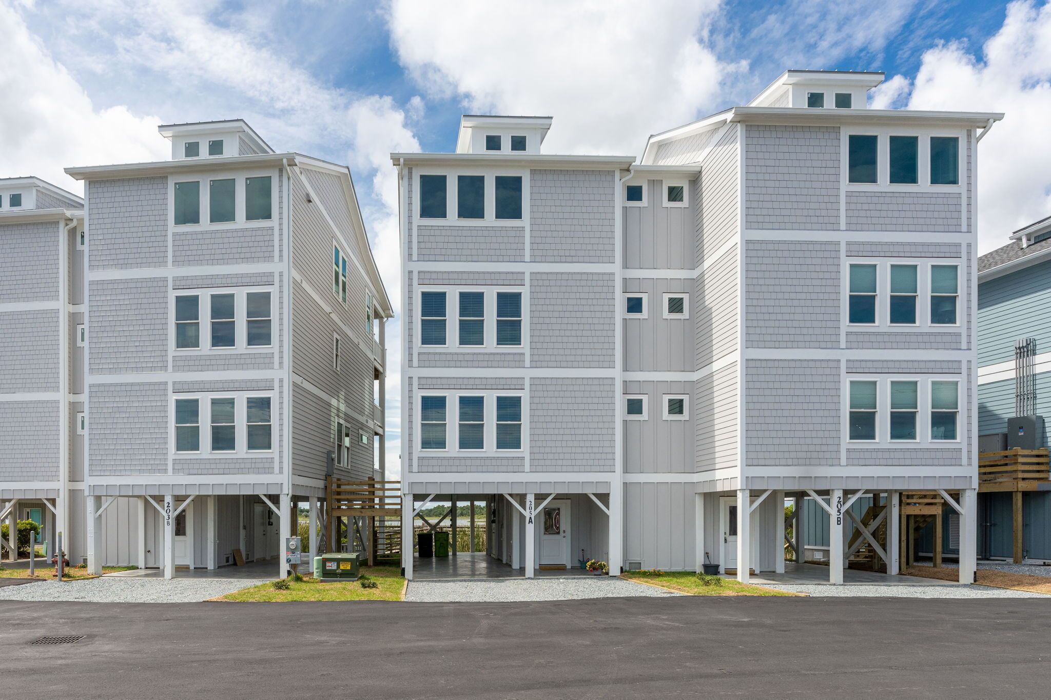A multi-story hotel with a modern design, featuring a covered entrance and a parking area.