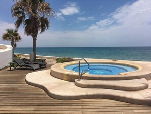 A pool area with a hot tub, lounge chairs, and palm trees. - Amazing Beachfront Condo, Tessoro at Las Conchas, Puerto Penasco (Las Conchas)