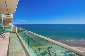 Un balcon offrant une vue dégagée sur l’océan et la plage.