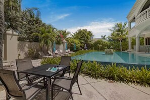 Ein Poolbereich mit Liegestühlen, einem Tisch und einem Pool.