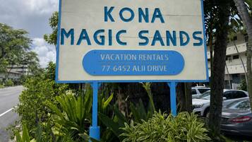 A sign for Kona Magic Sands with a blue background and white text, indicating it's a vacation rental.