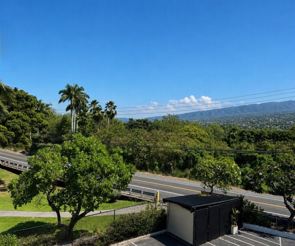 A parking area with a clear view of a road and distant mountains.
