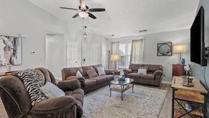 A living room with two sofas, a coffee table, a ceiling fan, and a TV. - 7 Miles to Horse Park/ King Size (Georgetown)