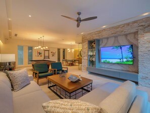 A modern living room with a pool table, comfortable seating, a flat-screen TV, and a ceiling fan. - apartment (Bucerías)