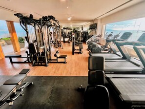 A gym with various exercise equipment, a treadmill, and a view of the ocean. - apartment (Bucerías)