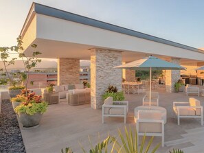 Uma área de pátio ao ar livre com assentos, um bar e um muro de pedra.