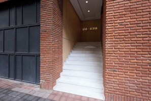A brick staircase leading to a wooden door with the sign 'ESTADA LIVING HISTORY'. - Studio · Private balcony, parking, rooftop & BBQ (Ciudad de México)