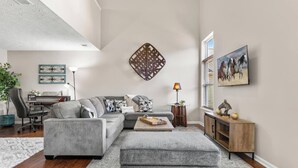 Una sala de estar moderna con un sofá modular, una mesa de centro, un escritorio y una lámpara.
