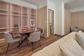 A modern living room with a round dining table, two chairs, a beige sofa, and a wooden bookshelf. - Studio boutique  Free parking & rooftop - Oniria (Ciudad de México)